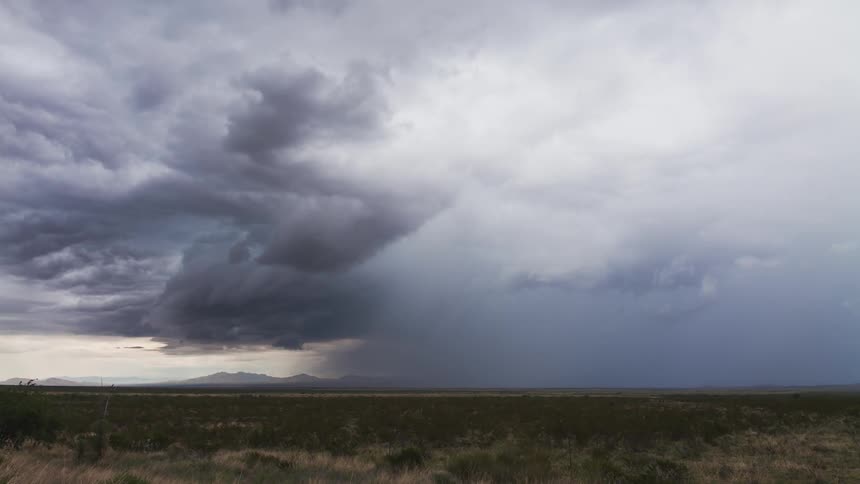Time lapse of storm clouds moving over a plain