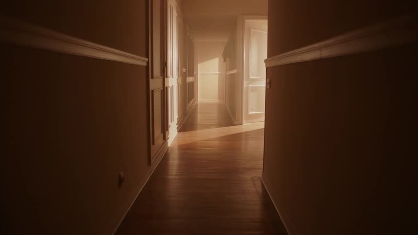 The sun is moving across a hallway inside a house during the day