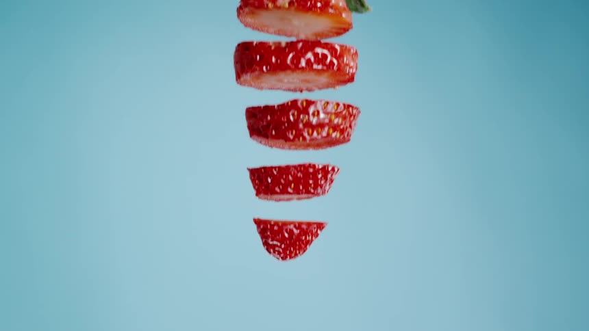 A sliced strawberry is falling from the above