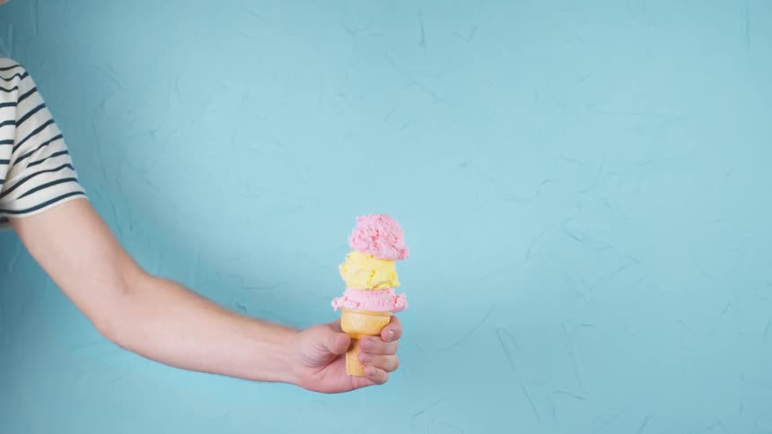 An ice cream cone falls into a persons hand