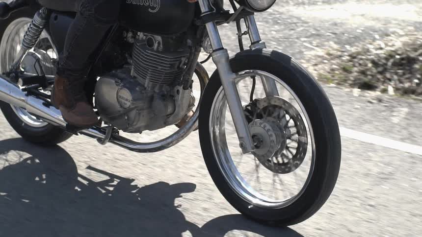 A motorcyclist rides down a road