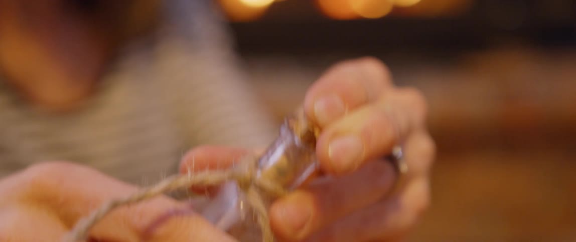 A woman puts a cork in a bottle