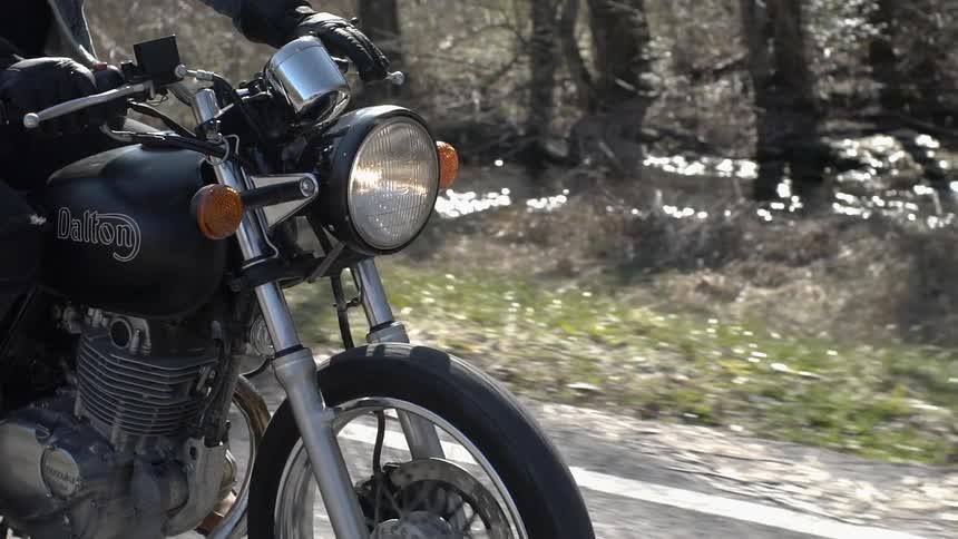 Person rides a motorcycle next to a railing