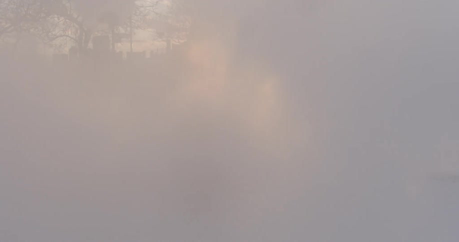 A man dances in steam by the street