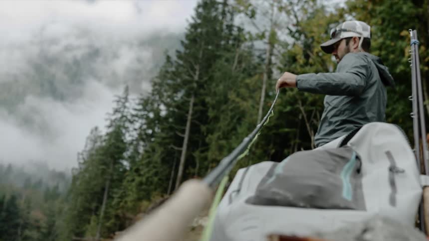 A man pulls fishing line from his fishing rod