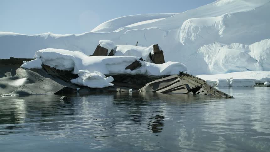 Water ripples off a snow covered shipwreck in the winter