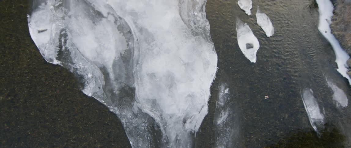 A river flows by a large sheet of ice
