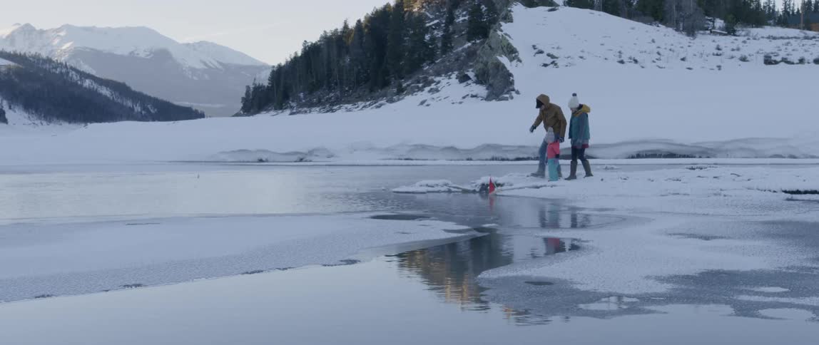 A family walks together in the snow