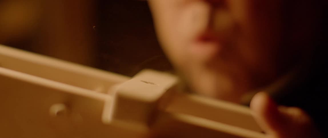 A man blows dust off of a wooden toy