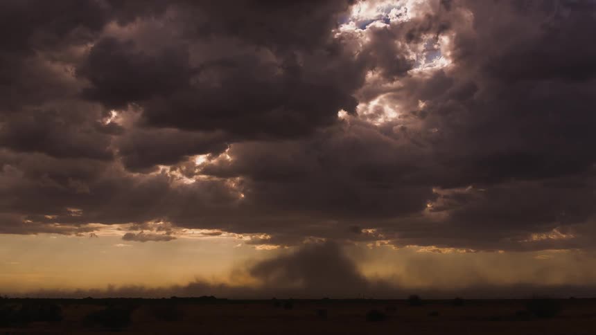 The sun shines through floating clouds