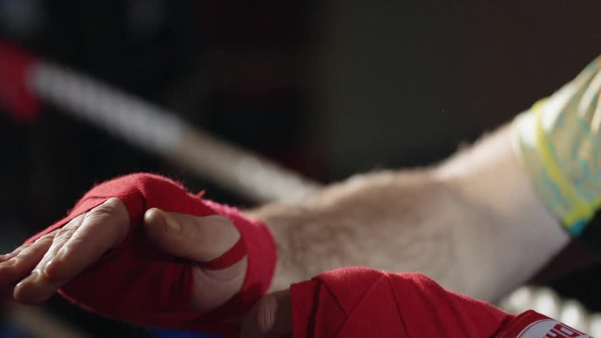 A man wraps his hand with tape