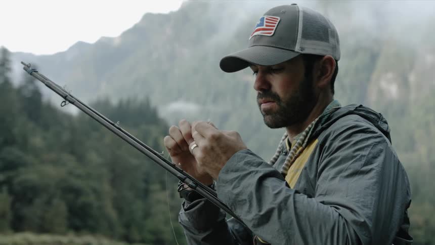 A man attaches a lure to his fishing line
