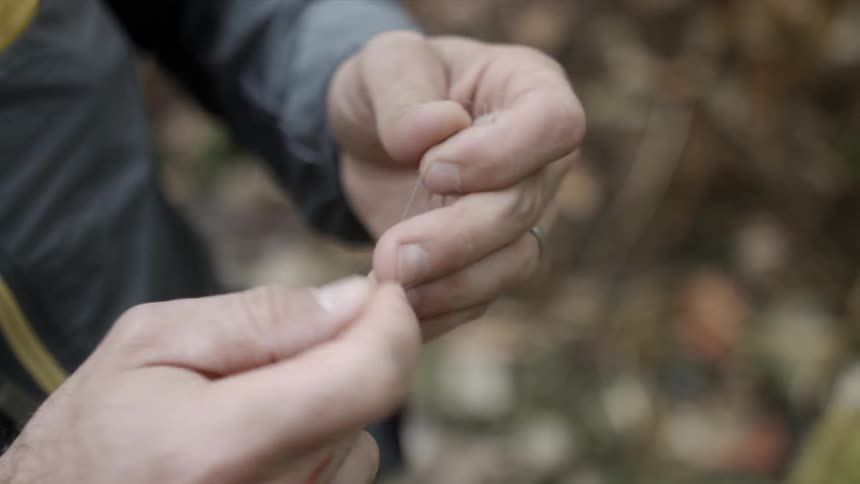 A man ties a fishing line