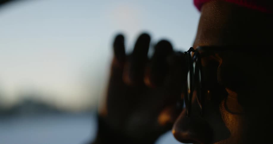 A person opens their sunglass lid on their glasses