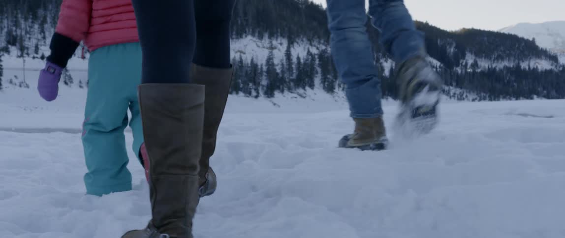 A family walks together in the snow