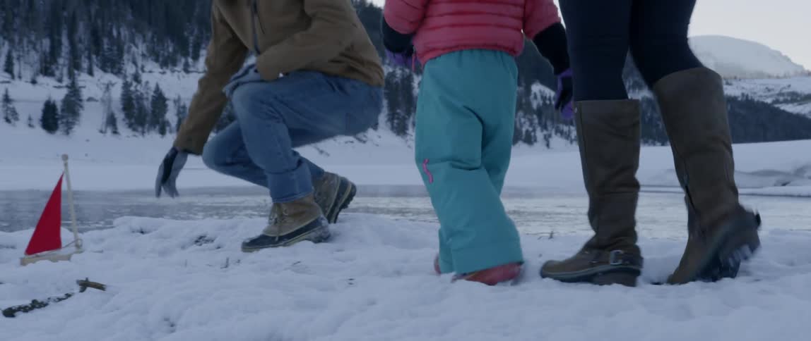 A family walks together through the snow