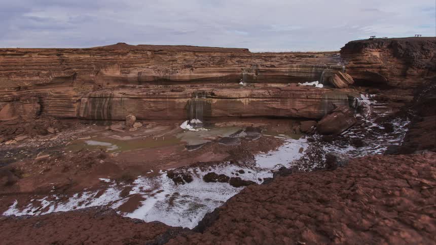 A high mesa is shown covered in snow