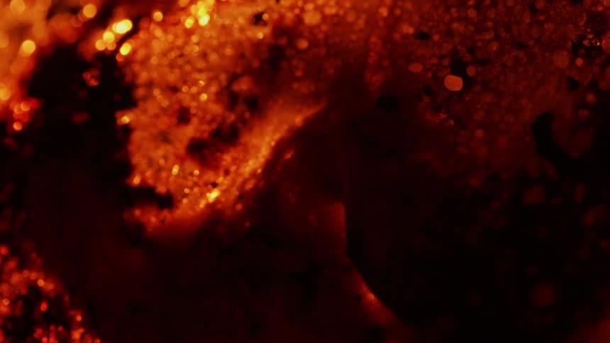 An orange surface bubbles and expands as it heats