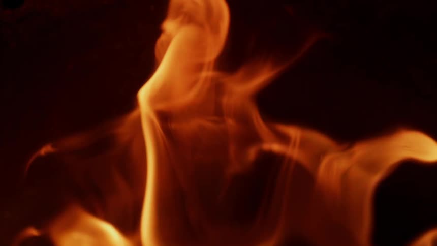 A fire burns in the dark