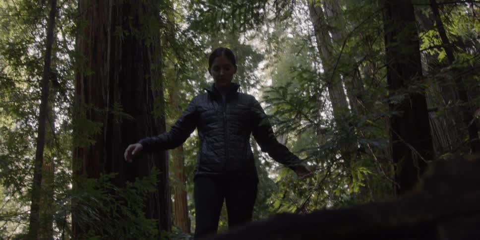 Woman walks carefully through the forest