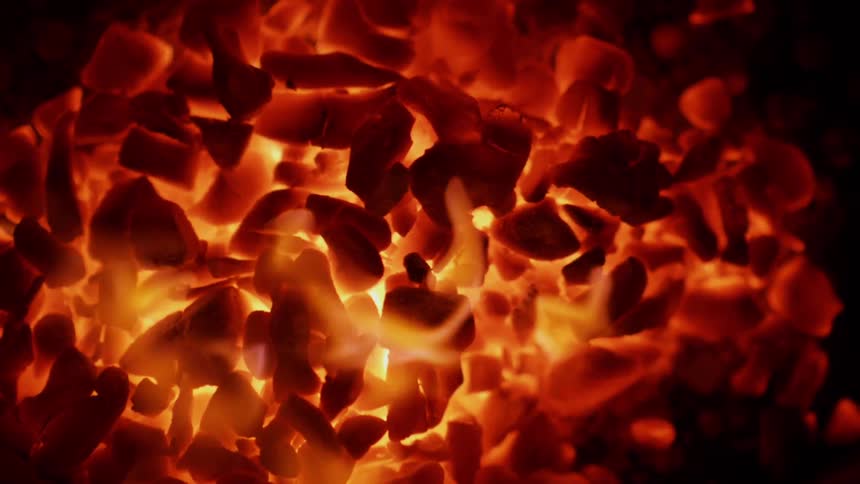 Flames are swirling among coals in a fire