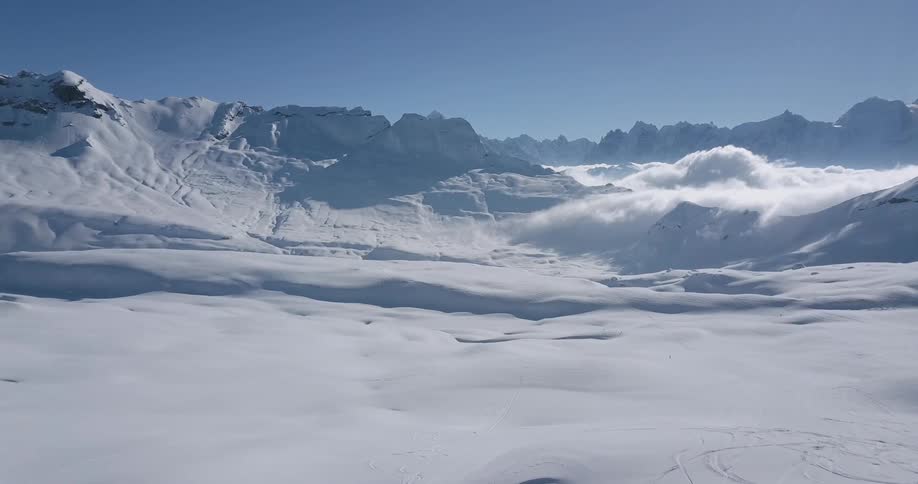 Low clouds cover snow covered peaks