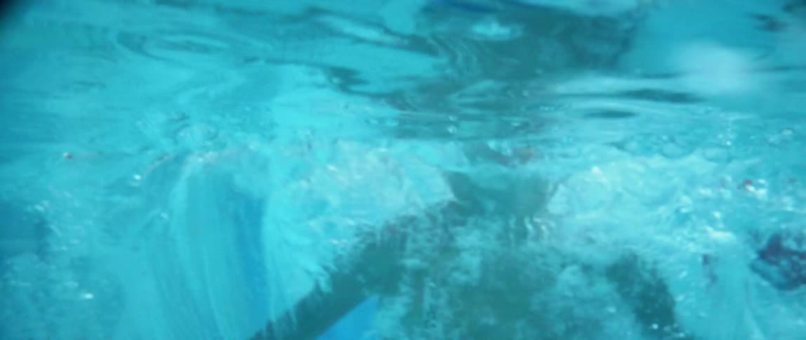 A young boy dives into the swimming pool