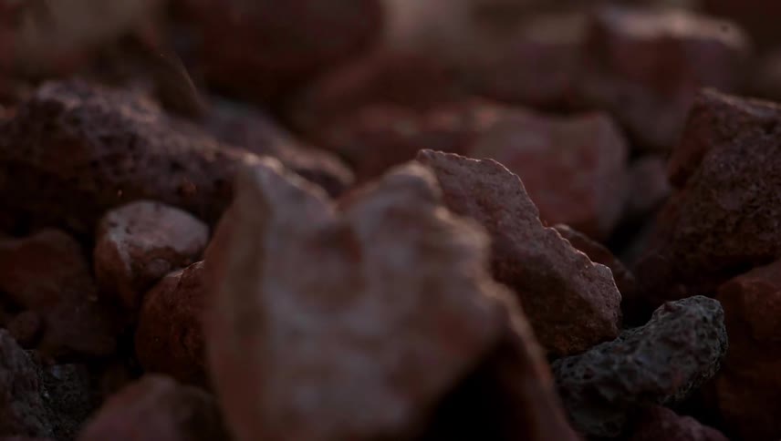 Small stones fall onto the large rocks