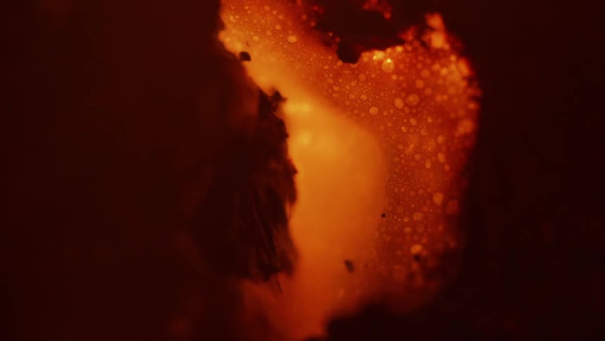 An orange surface browns and bubbles as it heats