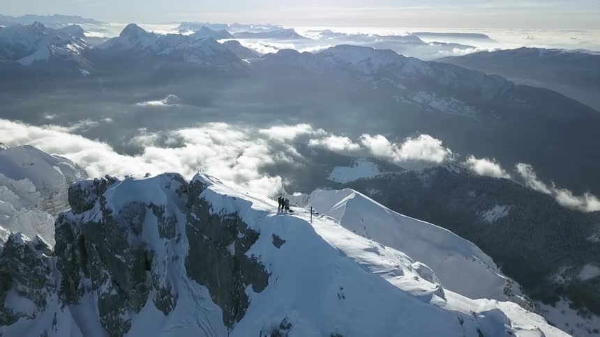 People stand on top of a snow covered mountain