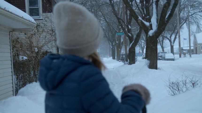 A woman stands out in the falling snow