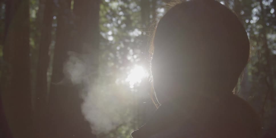 A woman stands in a forest