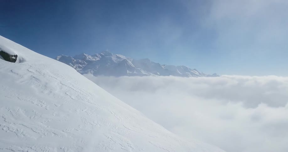 Sun shines off tall snowy mountains
