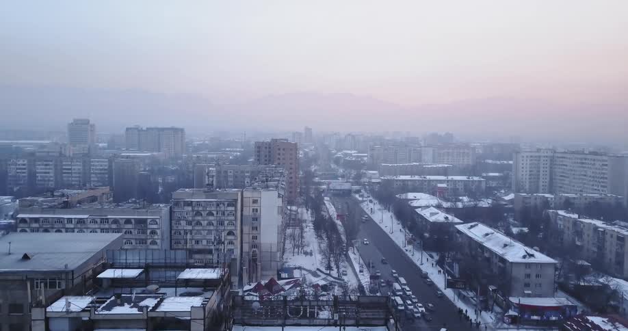 Traffic moves on a city street in winter