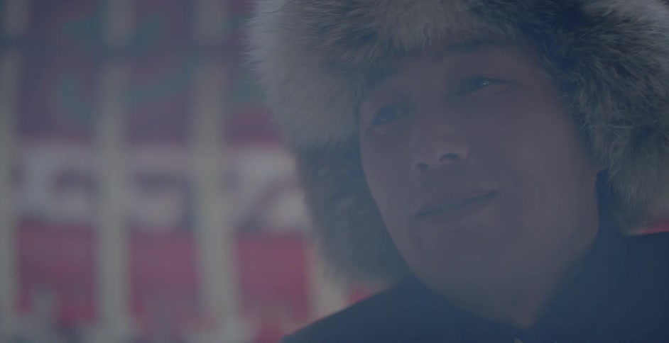 Smoke blows around a man wearing a furry hat