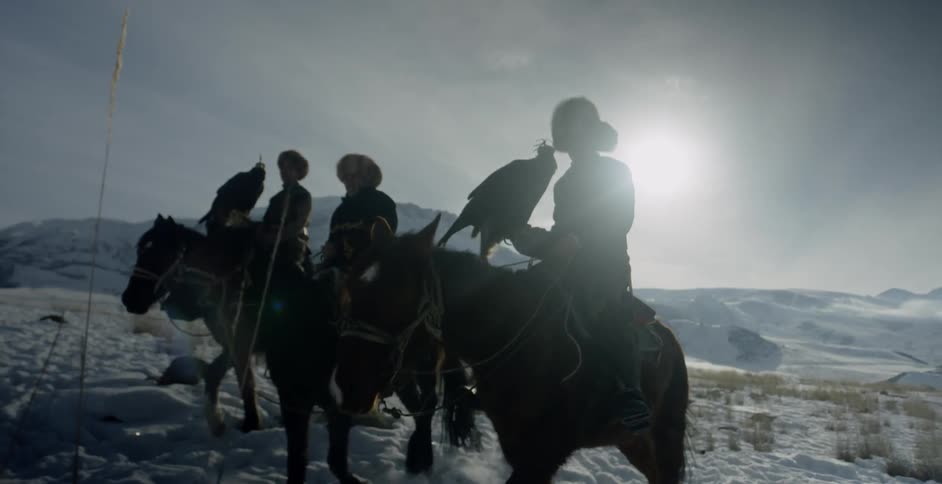 People on horses carrying birds in a snowy plain