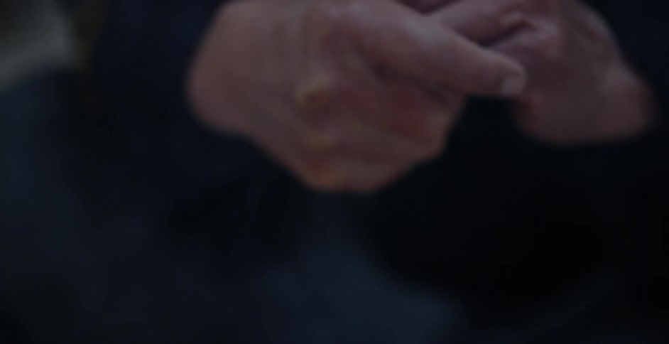 A man warms his hands by a fire