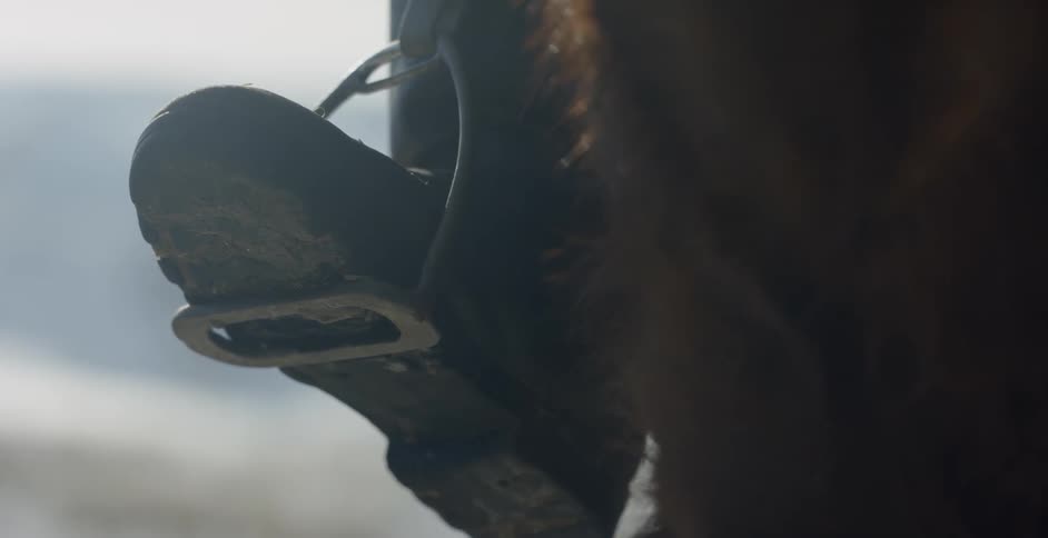 A horse rider rests his foot in a stirrup