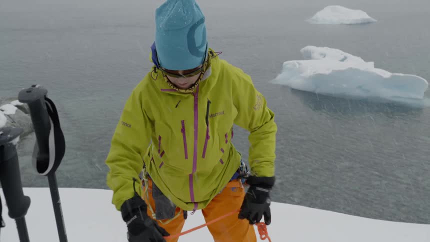 Person straightens rope outside in the snow near a body of water