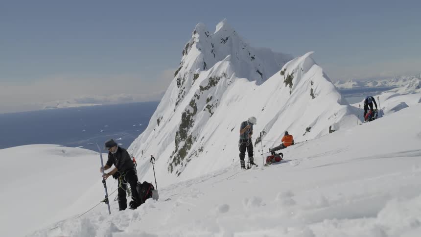 Skiers stand in snowy mountains