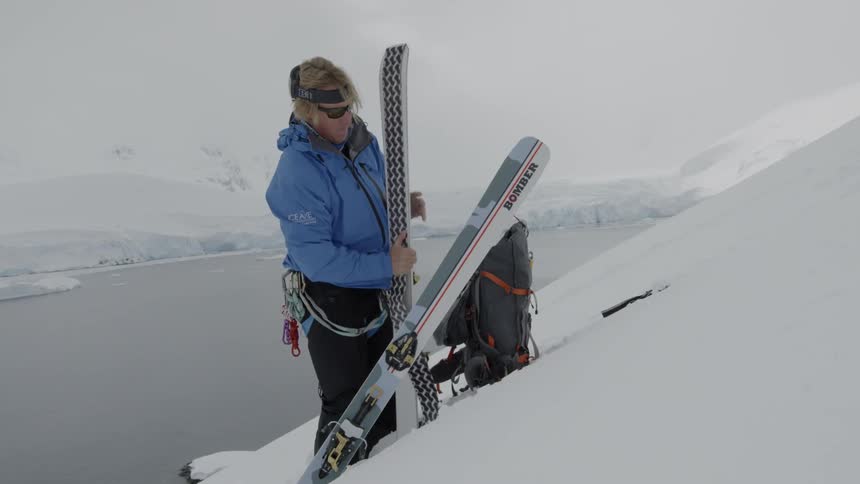 A skier stands on a snowy mountainside