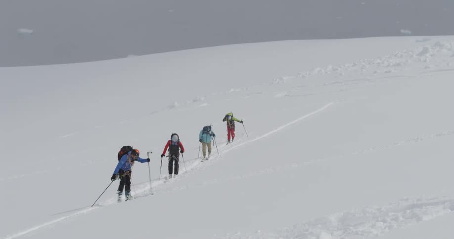 People hiking up a snowy hill