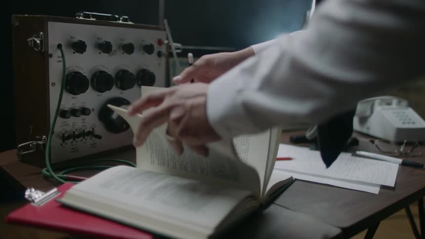 A man flips through a book on a table