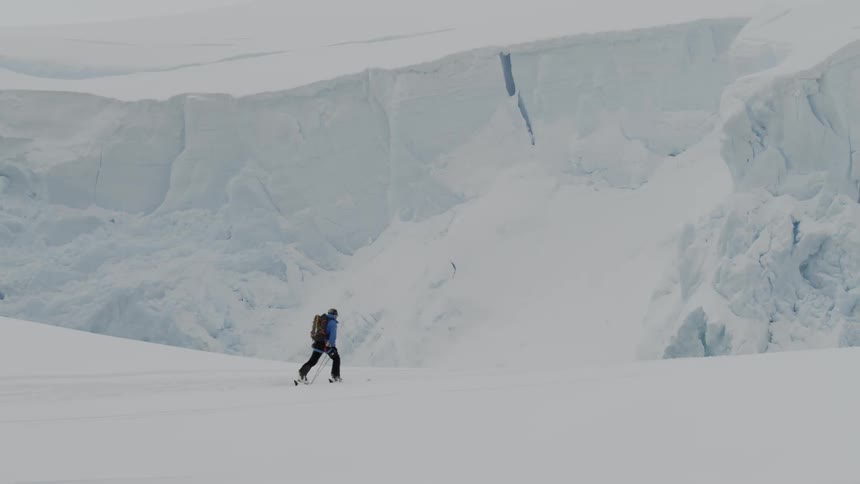 A skier walks across a snowy expanse