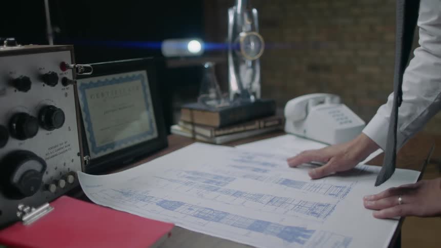 A man looks at blueprints on a table