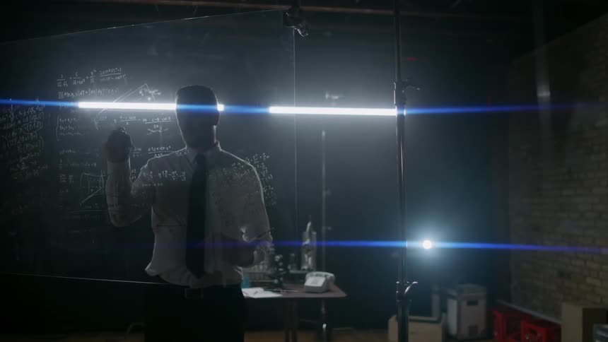 Man writes with a marker on a piece of clear glass