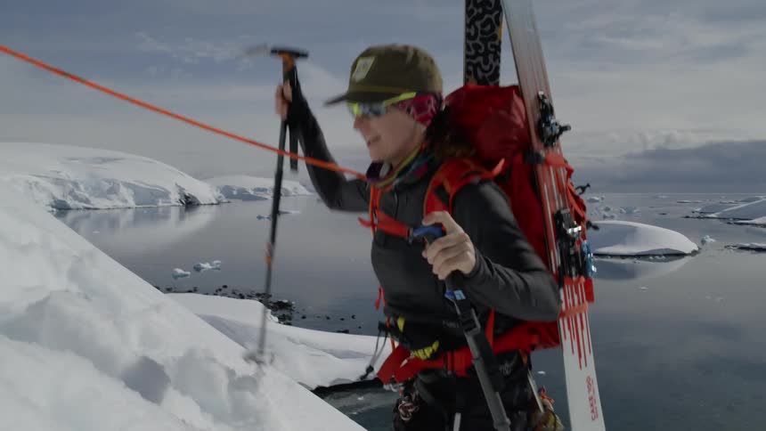 A man looks up smiling as he climbs the slope