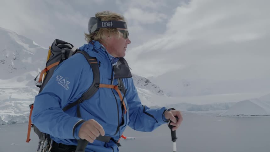 Man pushes himself up the mountain with trekking poles