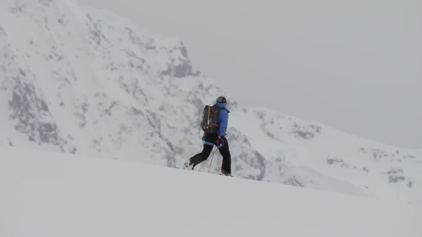 A person is slowly hiking over the snow ahead