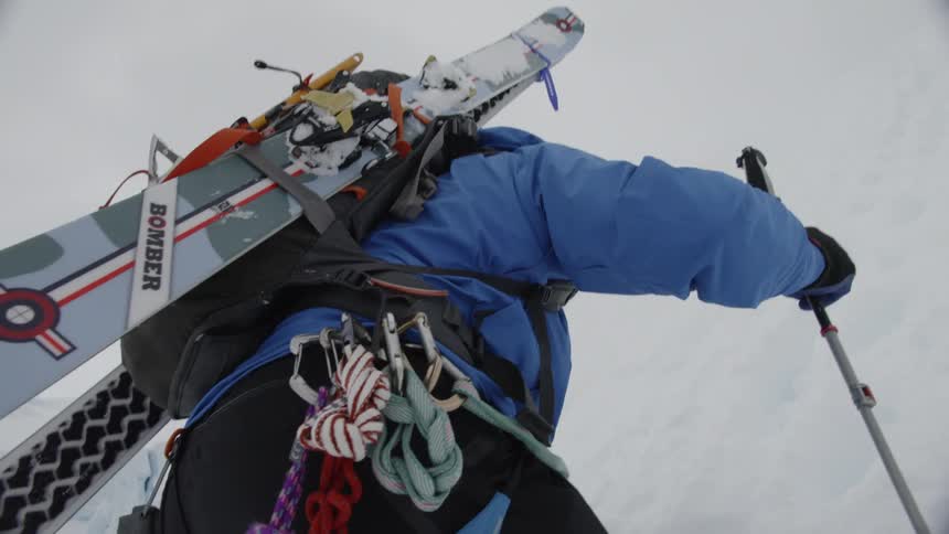 A person climbs a snowy hill